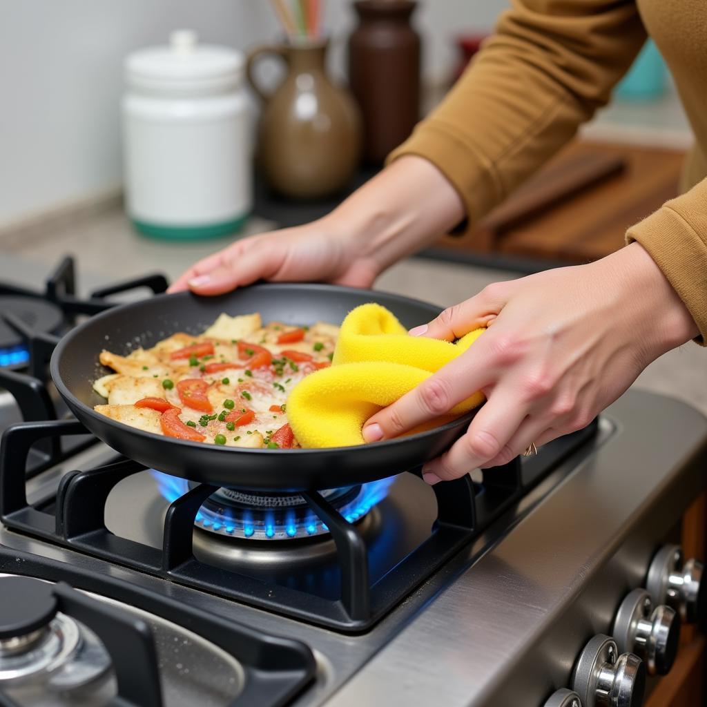 person-cleaning-a-stainless-steel-gas-food-warmer-with-a-sponge