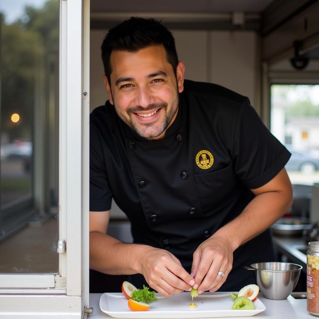 Chef Miguel Rodriguez smiling warmly while preparing food inside the Fat Belly Food Truck