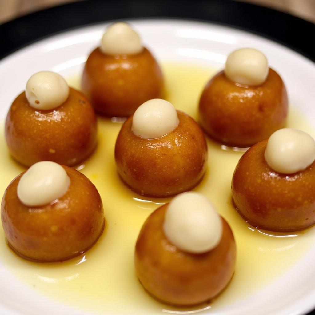 A plate of colorful Indian desserts - Gulab Jamun and Rasmalai