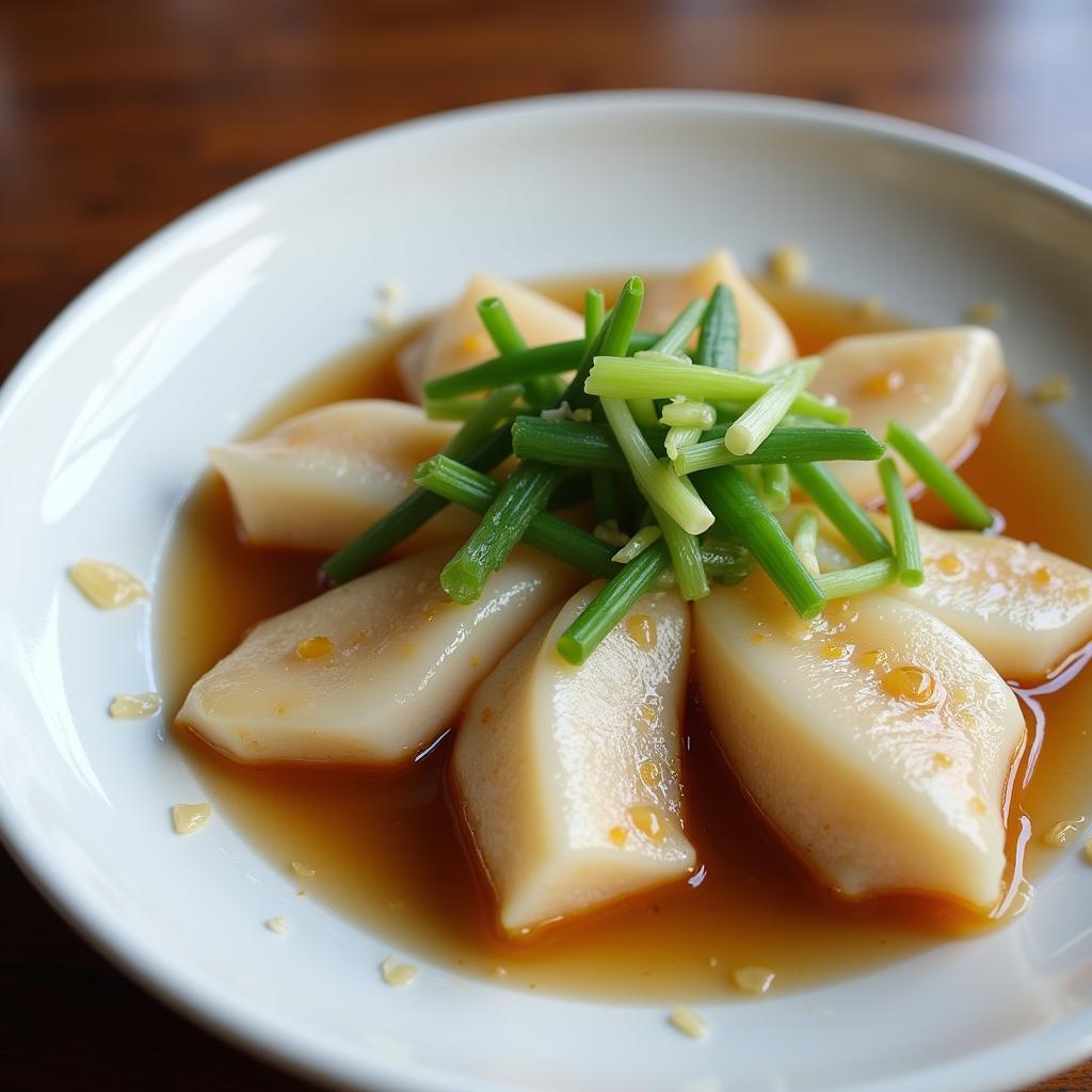 Steamed fish with ginger and scallions in a white dish