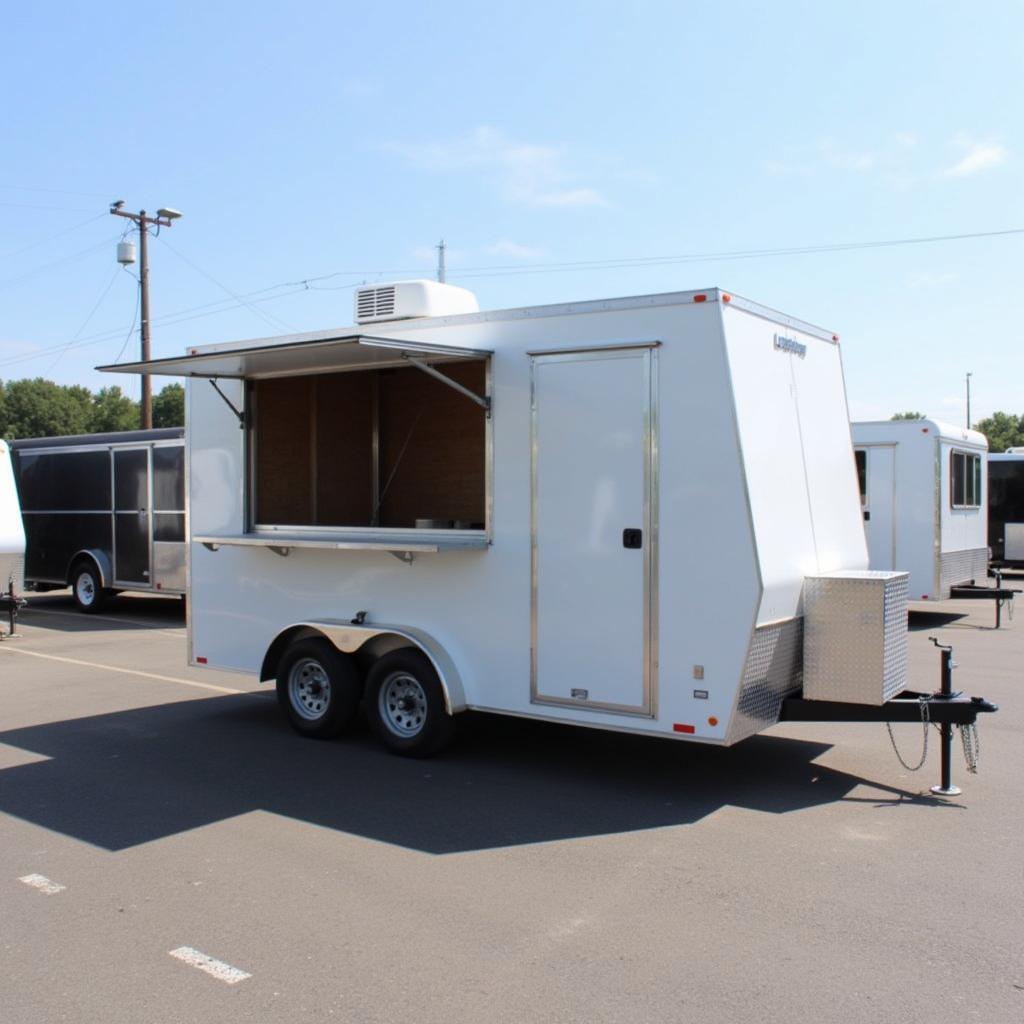 A used food trailer for sale in Illinois parked at a dealership lot