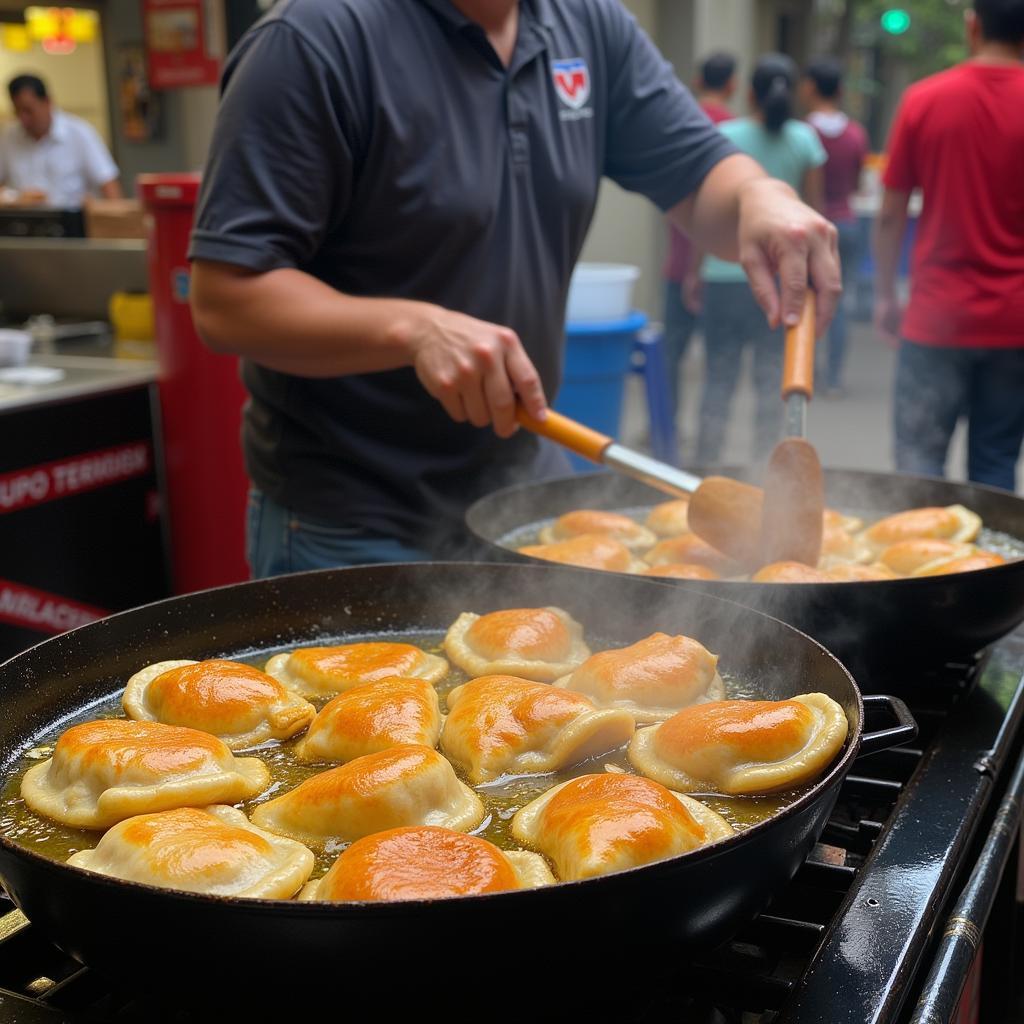 Colombian street food vendors preparing and frying empanadas in a large pan at a local market.