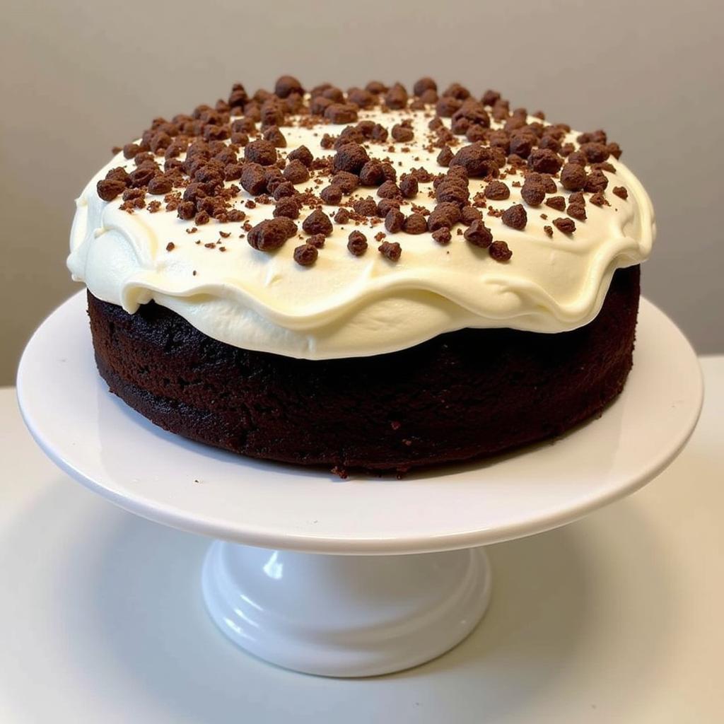 A whole devil's food cake with cream cheese frosting, ready to be sliced and served.