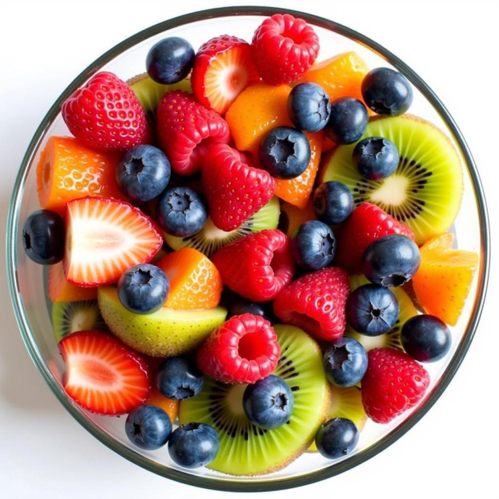 Freshly made fruit cocktail with strawberries, blueberries, raspberries, and kiwi, ready to top an angel food cake.