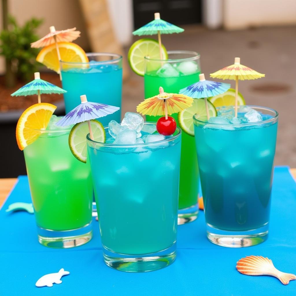 Colorful ocean-themed drinks with blue and green hues, garnished with fruit slices and umbrellas.