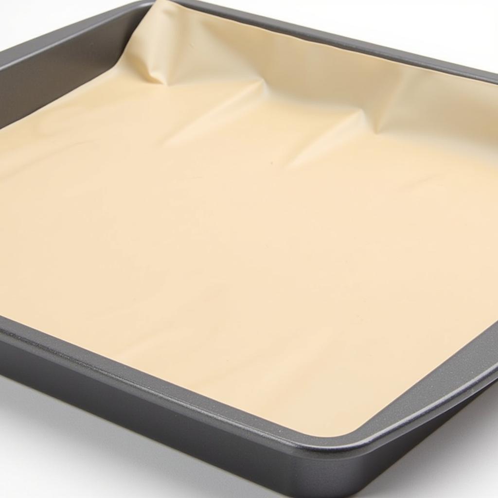 Silicone Baking Mat on a Baking Tray: A close-up view of a silicone baking mat placed on a metal baking tray, ready for use.