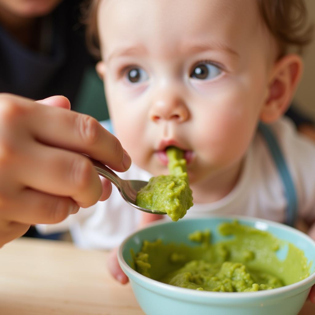 A parent lovingly feeding their baby a spoonful of vegetable puree