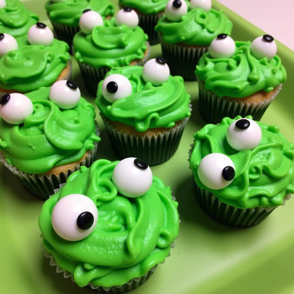 Frog-shaped cupcakes with green frosting and candy eyes